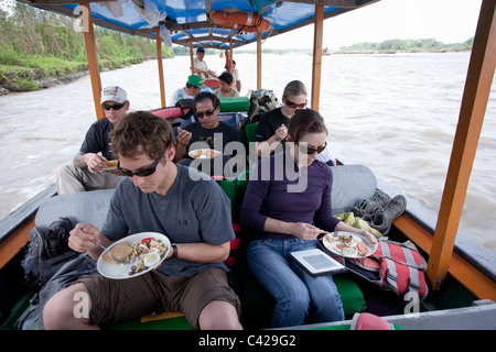 Peru, Boca Manu Manu Nationalpark, UNESCO-Weltkulturerbe, Fluss Rio Madre de Dios. Touristen im Boot mit Mittagessen. Stockfoto