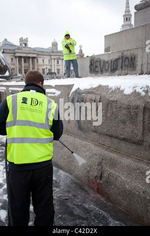 Graffiti aus studentischen Proteste wird von Nelson Säule vor Weihnachtsbaum Beleuchtungszeremonie auf dem Trafalgar Square gereinigt. Stockfoto