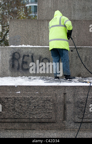 Graffiti aus studentischen Proteste wird von Nelson Säule vor Weihnachtsbaum Beleuchtungszeremonie auf dem Trafalgar Square gereinigt. Stockfoto