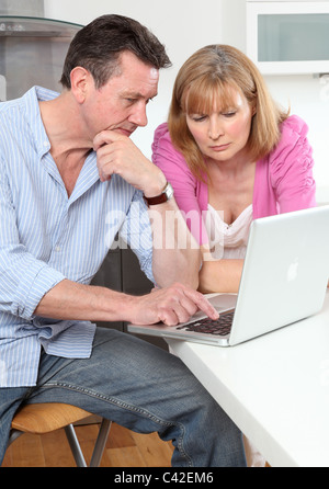 Betroffenen paar auf der Suche auf einen Laptop zusammen. Stockfoto