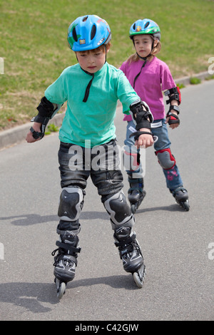 Bruder und Schwester Inline-Skaten zusammen Stockfoto