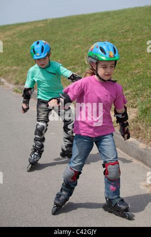 Bruder und Schwester Inline-Skaten zusammen Stockfoto