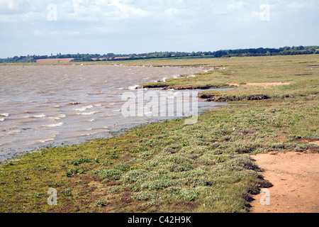 Starke Winde erzeugen Wellen verursachen Erosion, Marschen River Deben von Bawdsey Blick stromaufwärts, Suffolk, England Stockfoto