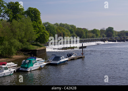 Teddington Wehr und dem Fluss Themse bei Flut mit Booten vertäut durch eine Eyot in der Nachmittagssonne Stockfoto