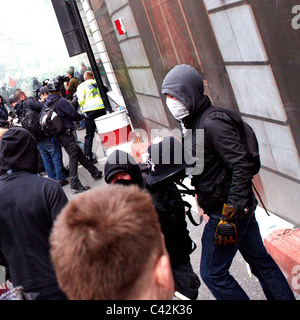 Maskierte Jugendliche mit Polizeihelm während der Störung auf dem Marsch zur Alternative Stockfoto