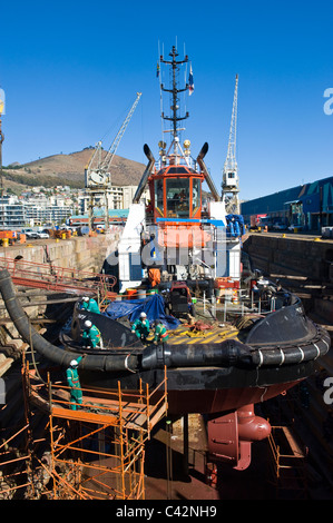 Arbeitnehmer, die Reparatur von einem Schlepper in einem trockenen dock in Cape Town, South Africa Stockfoto