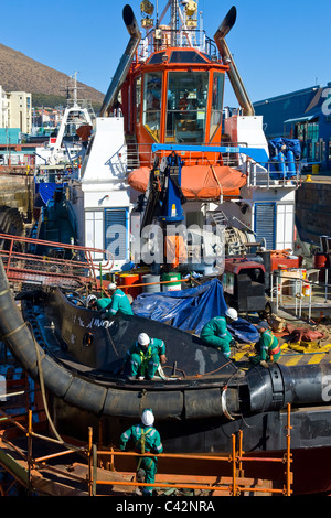 Arbeitnehmer, die Reparatur von einem Schlepper in einem trockenen dock in Cape Town, South Africa Stockfoto