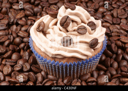 Kaffee-Kuchen über einen Kaffeebohnen-Hintergrund Stockfoto