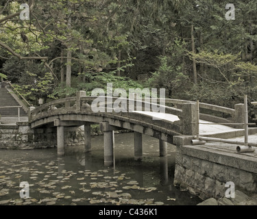 Dekorative steinerne Brücke über einen kleinen Teich in einem Shinto-Tempel Stockfoto