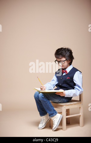 junge studieren auf Stuhl Stockfoto