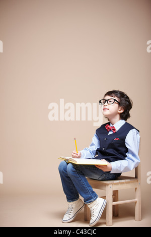 junge studieren auf Stuhl Stockfoto