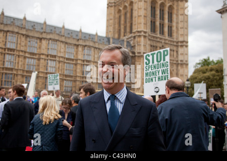 Die UKIP Führer Nigel Farage lächelt außerhalb des Parlaments bei einem Pro-Kürzungen Protest zur Unterstützung der Regierung steuerliche Einsparungen. Stockfoto