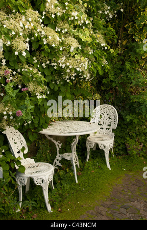 Weißes Gusseisen Garten Tisch und Stühle in einem Garten hinter dem