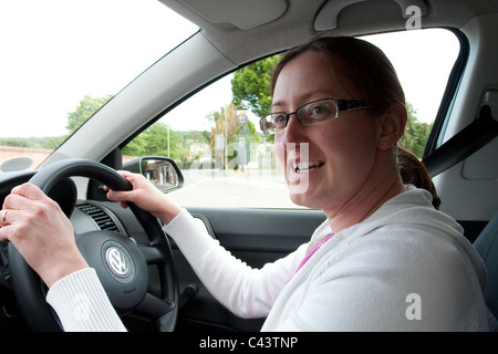 Junge Frau fährt einen VW Polo in UK Stockfoto