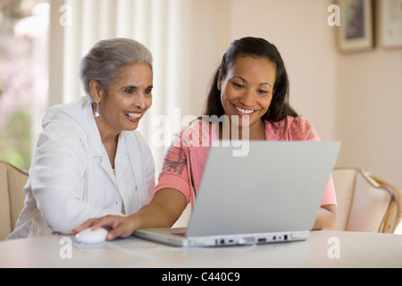 Attraktive schwarze Mutter und Tochter mit computer Stockfoto