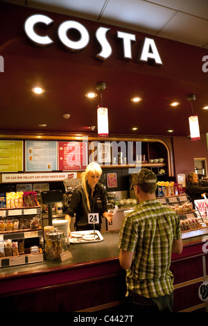 Ein Barista serviert ein Kunde, Costa Coffee Café, Exeter Autobahnraststätten, M5, Devon, UK Stockfoto