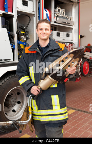 Bild von einem jungen und erfolgreichen Feuerwehrmann bei der Arbeit Stockfoto