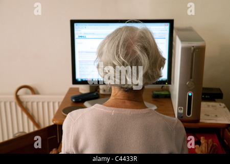 Ein älterer Silber Surfer, die mit ihrem Computer zu Hause Zugriff auf das Internet im Vereinigten Königreich Stockfoto