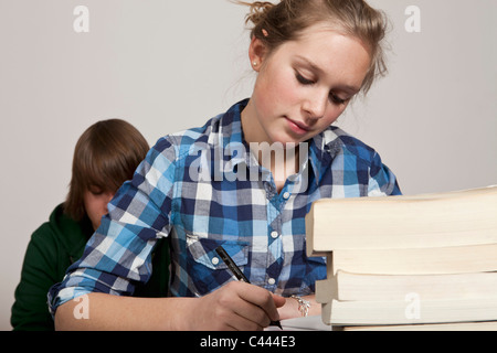 Ein junges Mädchen Arbeit Klasse, junge im Hintergrund Stockfoto