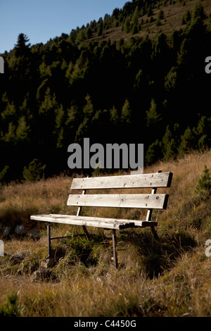 Eine hölzerne Sitzbank in einer Berglandschaft Stockfoto