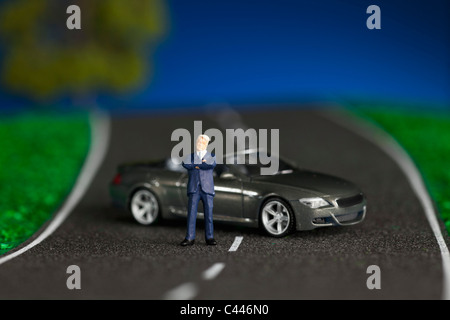 Eine Miniatur Geschäftsmann Figur und Miniatur-Sportwagen Stockfoto