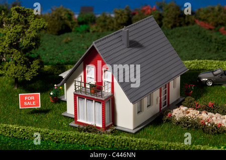 Ein Diorama ein Miniaturhaus mit dem FOR SALE Schild Stockfoto