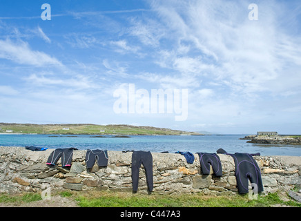 Nassen Badesachen trocknen an der Wand auf Inishbofin, County Galway, Irland. Stockfoto