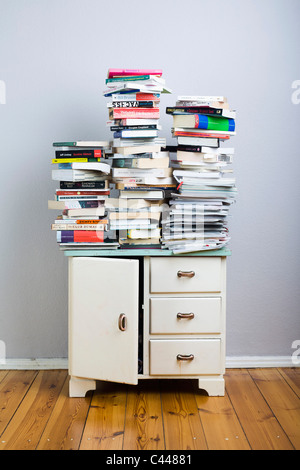 Bücherstapel auf einem Schrank Stockfoto