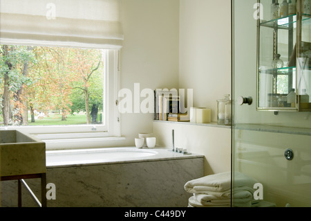 Carrara-Marmor-Badewanne und Waschbecken in weißen Badezimmer mit großem Fenster Stockfoto