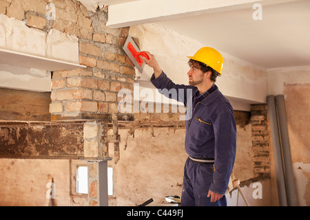 Ein Arbeiter eine Mauer Putz zuweisen Stockfoto