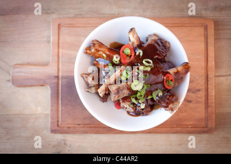 Ein Gourmet-Gericht aus klebrigen chinesischen Stil spare-Ribs serviert mit Chili, Ingwer und Frühlingszwiebeln Stockfoto