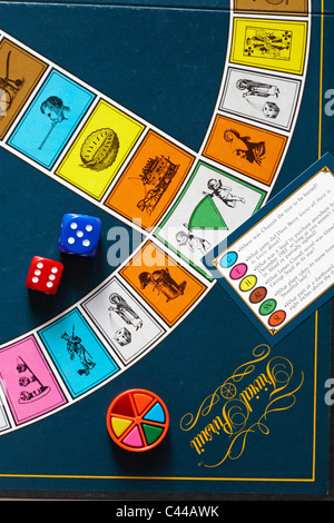 Spielen eines Spiels von Trivial Pursuit - Würfel, farbigen Keilkeilen und Frage Karte auf Trivial Pursuit Board - Trivial Pursuit Spiel Stockfoto