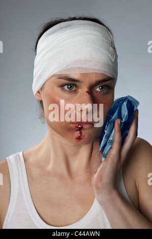 Eine Frau mit blauen Flecken und einem bandagierten Kopf Stockfoto