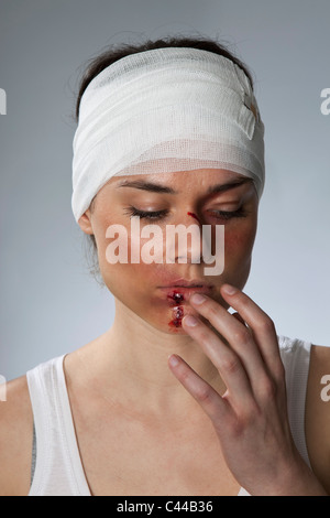 Eine Frau mit Verletzungen und einem bandagierten Kopf Stockfoto