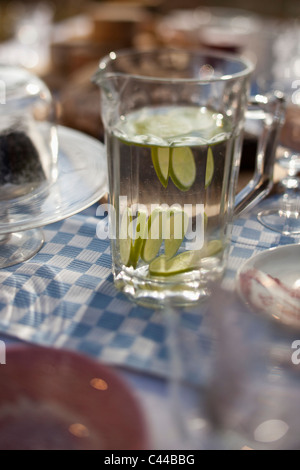 Krug Wasser mit in Scheiben geschnittenen Limetten am Esstisch außerhalb Stockfoto