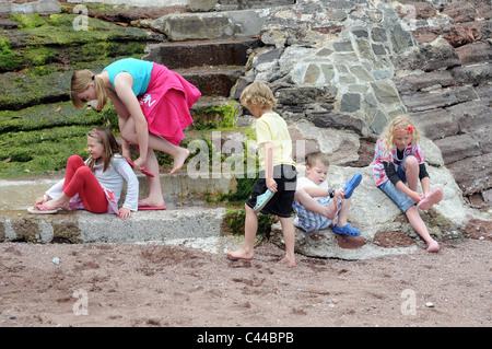 Kinder erkunden Felsen zeigen, Küstenerosion, South Devon an der englischen Riviera Devon, berühmten fünf Kinder mit sandigen Füßen Stockfoto