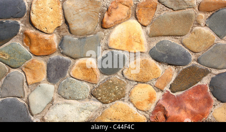 Steinwand des Hauses von unterschiedlicher Farbe von Steinen im Mauerwerk Stockfoto