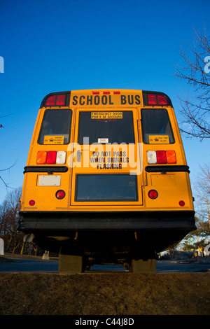 Ein Blick auf einen traditionellen gelben Schulbus von hinten. Stockfoto