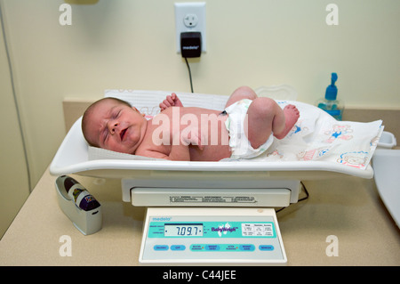 Eine Woche altes Baby wird gewogen, beim ersten Besuch beim Kinderarzt für Check Up Stockfoto