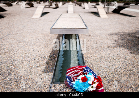 Blumen, die neben einer der Bänke des Pentagon Memorial platziert sind. Das Pentagon Memorial ist in Erinnerung an die Ereignisse des 11. September 2001, und die 184 Personen, die als Opfer des Terroranschlags auf das Pentagon gestorben. Das Denkmal ist angrenzend an der südwestlichen Seite des Pentagons. Designed by Julie Beckman und Keith Kaseman, das Denkmal für die Öffentlichkeit geöffnet am 11. September 2008, soll es mit einem für jedes Opfer des Angriffs, geordnet nach Alter der Person beleuchtet. Jede Bank hat einen kleinen Teich Wasser unter, und ein Name wird am Ende jeder Bank geätzt. Stockfoto