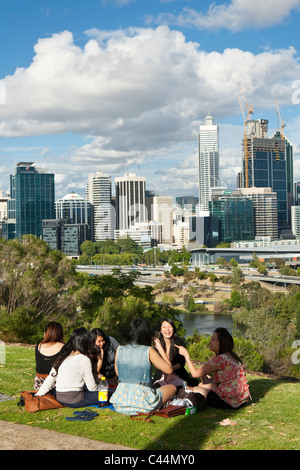 Frauen mit einem Picknick im Kings Park mit Skyline der Stadt im Hintergrund. Perth, Western Australia, Australien Stockfoto