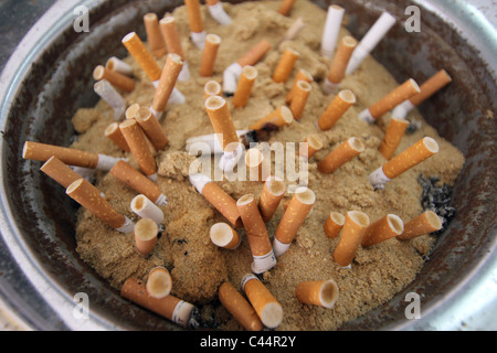 Zigarettenkippen in eine Sand gefüllten Aschenbecher gerodet. Stockfoto