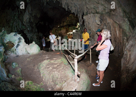 Touristen, die Sichtung Cemi Felsgravuren in San Gabriel Kalkstein-Höhle, Nationalpark Los Haitises, Dominikanische Republik Stockfoto