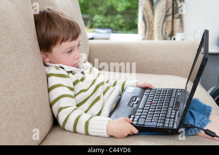 Drei Jahre alter Junge mit einem Laptop spielt Stockfoto