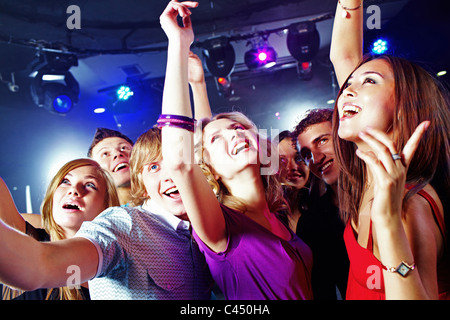 Bild von hübschen Mädchen tanzen mit ihren Freunden im Nachtclub Stockfoto
