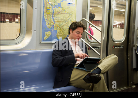 Apple iPad Benutzer liest während seiner u-Bahnfahrt in New York auf Dienstag, 31. Mai 2011 zu sehen. (© Frances M. Roberts) Stockfoto