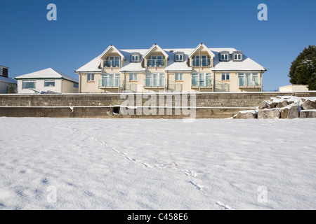 Newton, Porthcawl, Mid Glamorgan, Wales, Apartments direkt am Strand mit Schnee am Strand Stockfoto