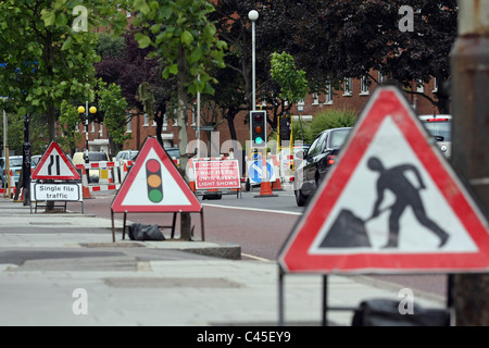 Fahrzeuge, die durch eine Reihe von Baustellen, die durch eine vorübergehende Reihe von Ampeln gesteuert Stockfoto