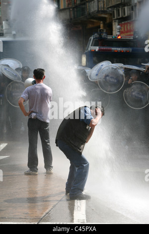 Männer protestiert und bekommt von Polizei Wasserwerfer getroffen Stockfoto