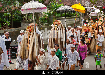 Ein BARONG Kostüm und LION Masken verwendet im LEGONG Tanz bei einem HINDU Umzug für einen Tempel Jubiläum - UBUD, BALI Stockfoto